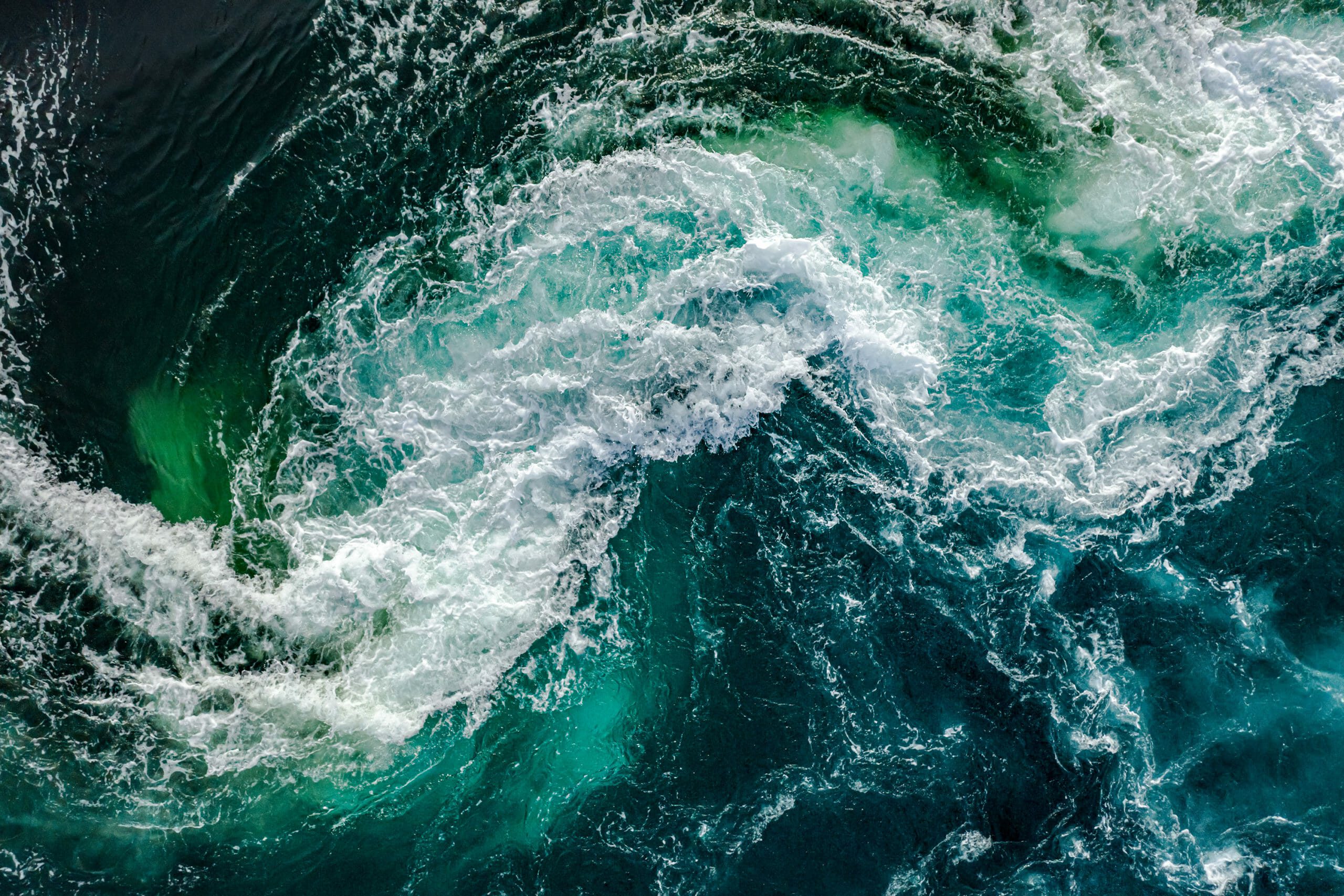 A two swirling waves of water crash into each other.